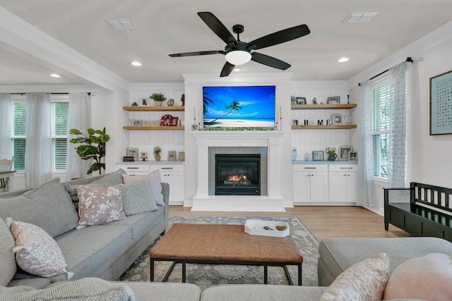 1576 Nautical Chart Dr, Charleston, SC 29414 - living room featuring crown molding, a ceiling fan, light wood-style floors, a glass covered fireplace, and plenty of natural light