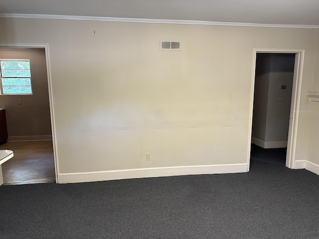 unfurnished room featuring ornamental molding, carpet flooring, baseboards, and visible vents