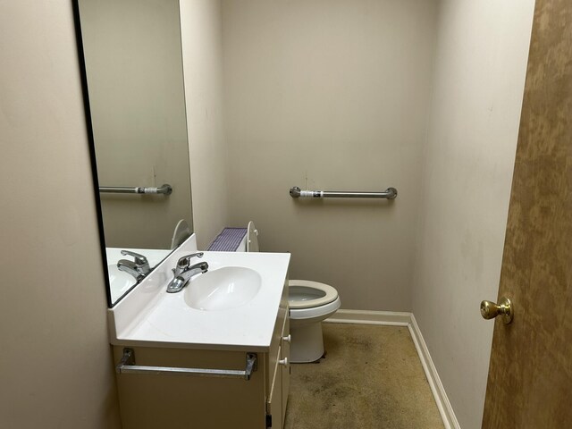 bathroom featuring vanity, toilet, and baseboards