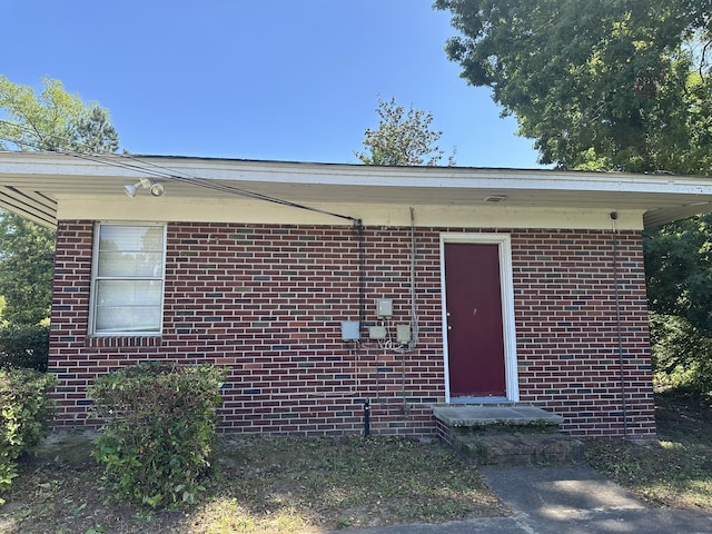 property entrance featuring brick siding