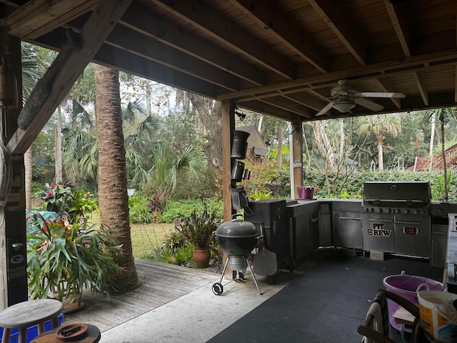 view of patio featuring ceiling fan, a wooden deck, and an outdoor kitchen