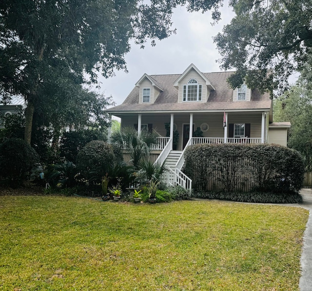 cape cod-style house featuring covered porch and a front lawn