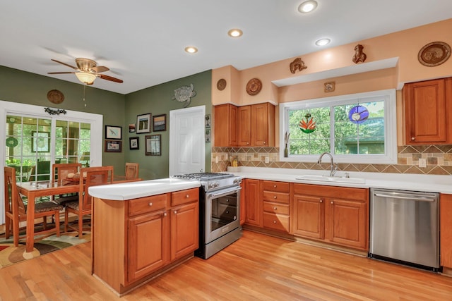 kitchen featuring decorative backsplash, sink, stainless steel appliances, and light wood-type flooring