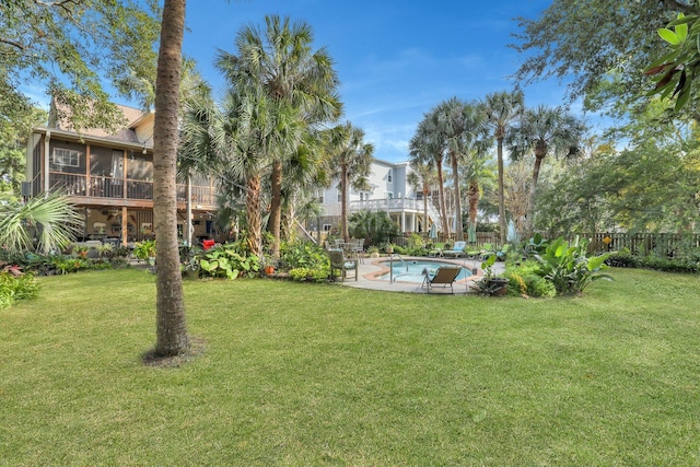 view of yard featuring a fenced in pool and a sunroom