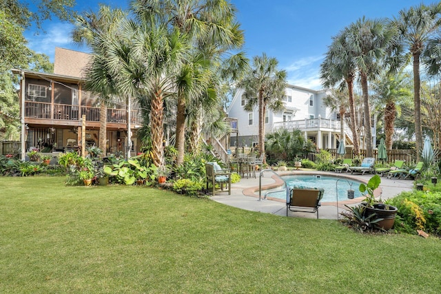 view of pool with a yard, a patio area, and a sunroom