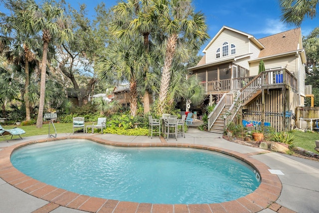 view of swimming pool featuring a patio area and a sunroom