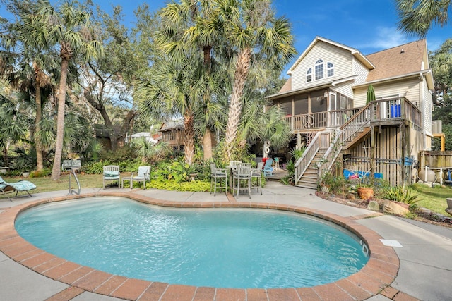 view of pool featuring a patio area and a sunroom