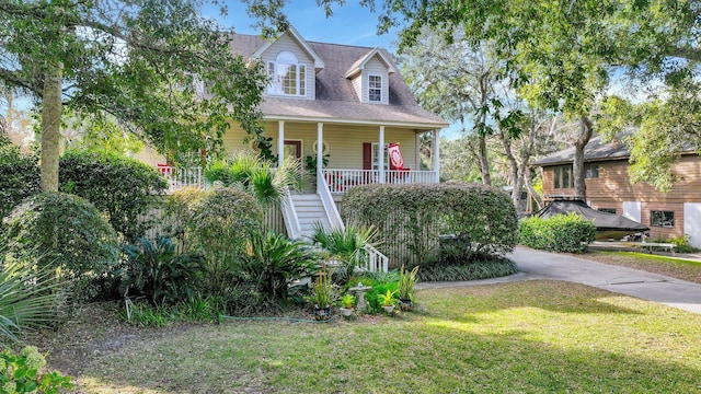 cape cod house with covered porch and a front yard