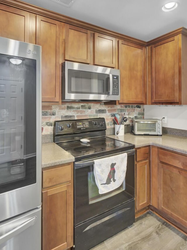 1005 Washitonia Way Unit B, Charleston, SC 29492 - kitchen with smart refrigerator, stainless steel microwave, electric range, brown cabinets, and light wood finished floors
