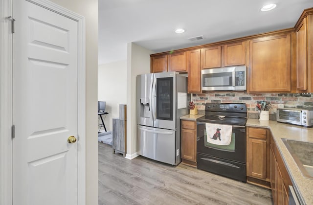 1005 Washitonia Way Unit B, Charleston, SC 29492 - kitchen with stainless steel appliances, brown cabinetry, light wood-style floors, tasteful backsplash, and recessed lighting