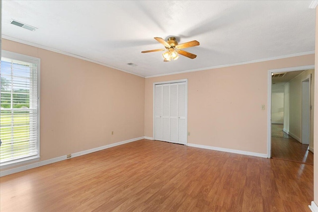 empty room featuring crown molding, hardwood / wood-style flooring, and ceiling fan