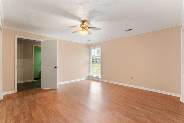 empty room with crown molding, hardwood / wood-style flooring, and ceiling fan