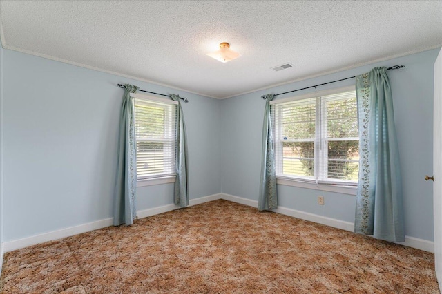 carpeted empty room with ornamental molding and a textured ceiling