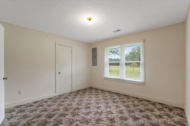 spare room with carpet floors, ornamental molding, electric panel, and a textured ceiling