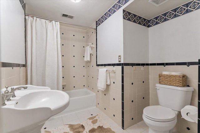 full bathroom featuring tile patterned flooring, tile walls, toilet, and shower / bathtub combination with curtain