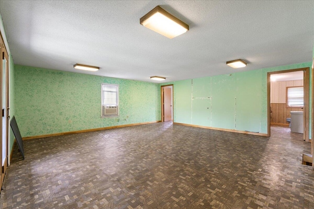 spare room featuring a textured ceiling, cooling unit, and parquet floors