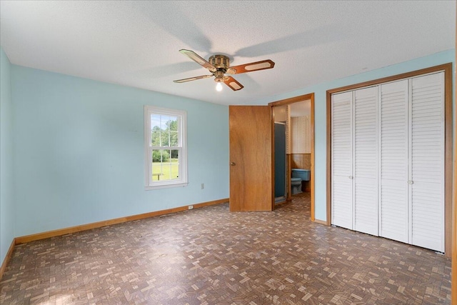 unfurnished bedroom featuring two closets, ceiling fan, dark parquet floors, and a textured ceiling