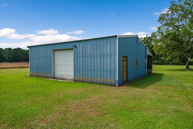 view of outdoor structure with a garage and a lawn