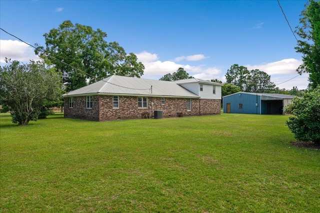 view of yard with central AC and an outbuilding