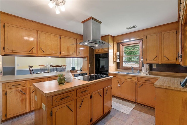 kitchen with light tile patterned floors, sink, black appliances, island exhaust hood, and a kitchen island