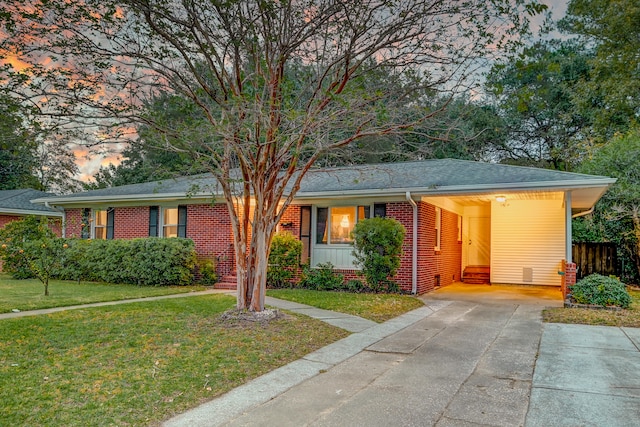 ranch-style home featuring a yard and a carport