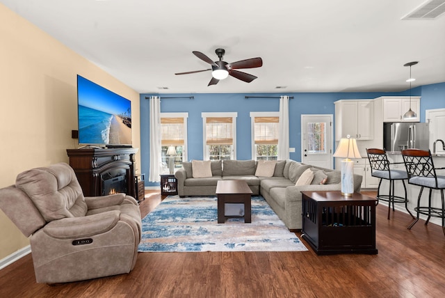 living room with dark hardwood / wood-style flooring, sink, and ceiling fan