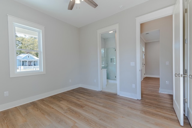 unfurnished bedroom with light wood finished floors, ceiling fan, baseboards, and ensuite bathroom