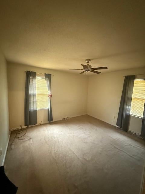 spare room featuring carpet floors and ceiling fan