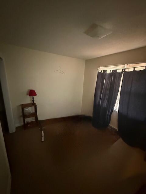 spare room with dark colored carpet