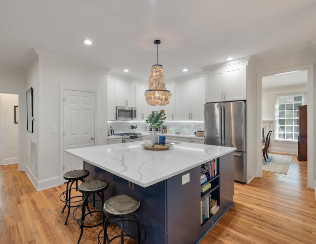 kitchen featuring stainless steel appliances, tasteful backsplash, a center island, and white cabinetry