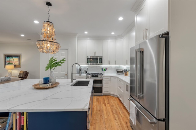 kitchen featuring white cabinets, a notable chandelier, a sink, and appliances with stainless steel finishes