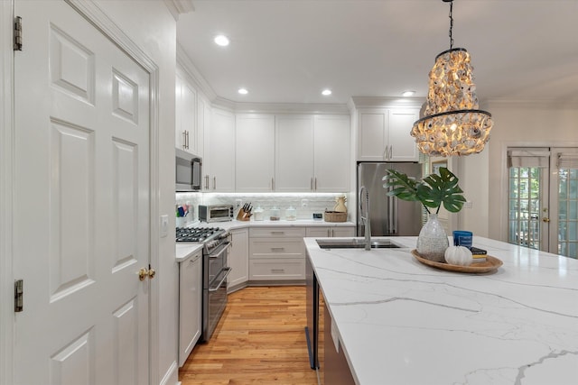 kitchen with stainless steel appliances, light wood-type flooring, crown molding, and white cabinetry