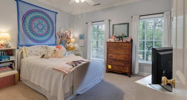 carpeted bedroom featuring crown molding, visible vents, and a ceiling fan