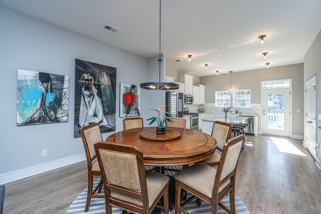 dining room featuring sink and light hardwood / wood-style floors