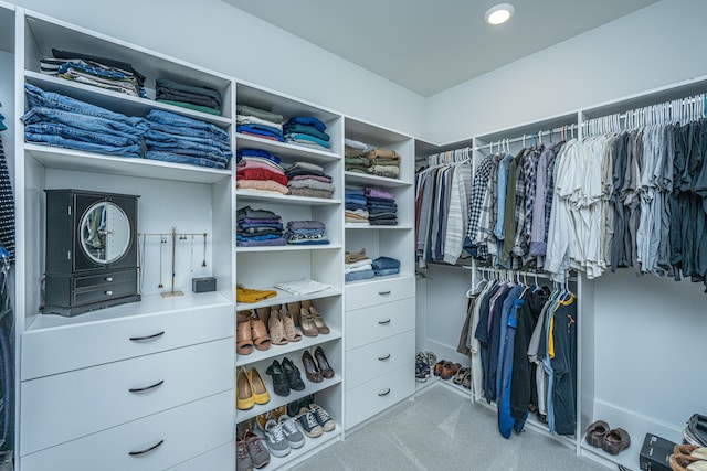 walk in closet with light colored carpet