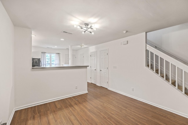 unfurnished room featuring hardwood / wood-style floors and a chandelier