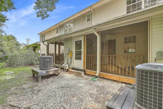 back of property with central AC unit, a sunroom, and ceiling fan