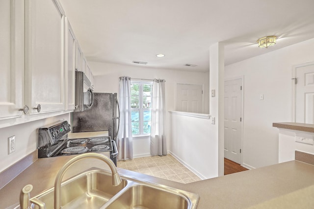 kitchen with sink, white cabinets, and stainless steel range with electric stovetop