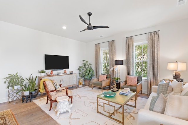 living room with ceiling fan and light hardwood / wood-style flooring