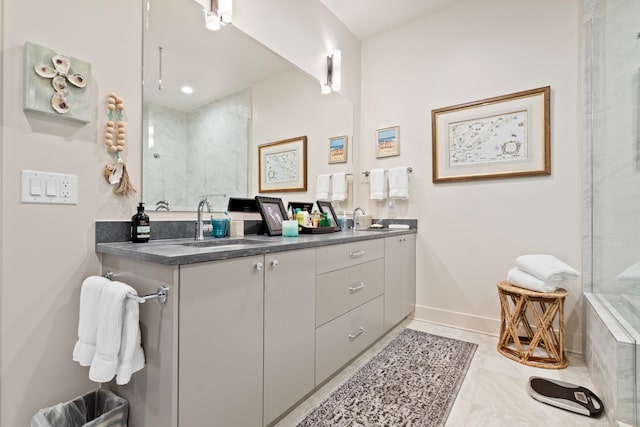 bathroom featuring a tile shower and vanity