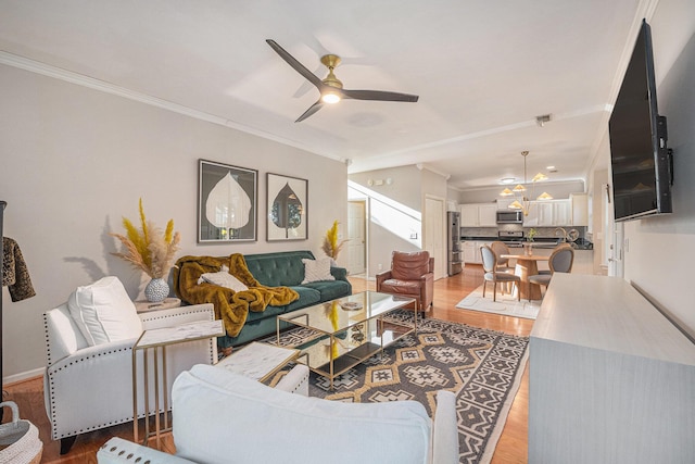 living room featuring light hardwood / wood-style flooring, ornamental molding, and ceiling fan