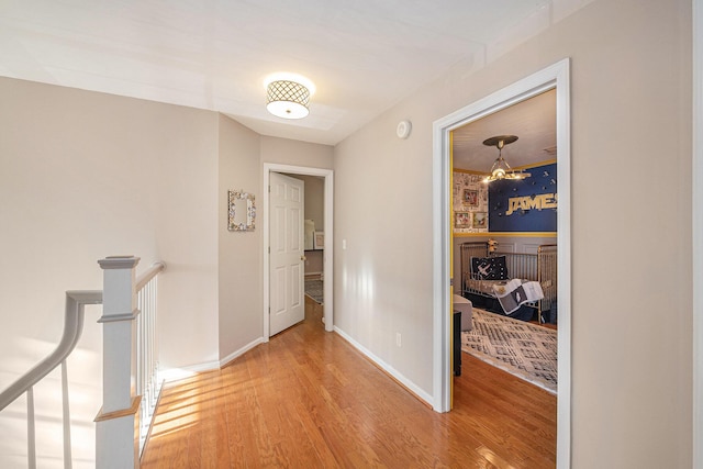 hall with hardwood / wood-style flooring and a chandelier