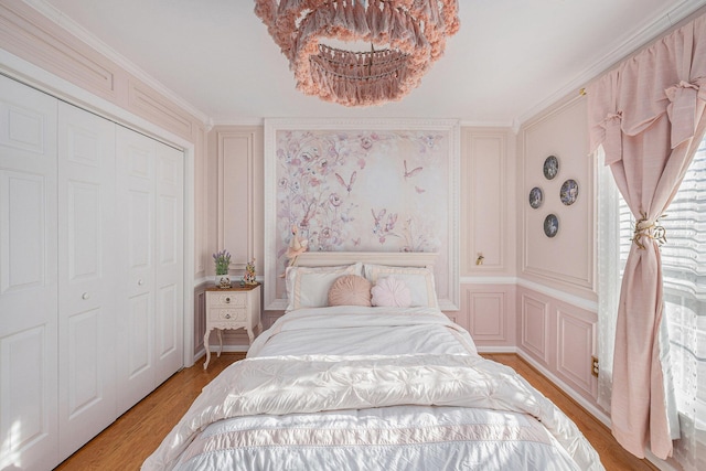 bedroom featuring crown molding, light hardwood / wood-style floors, and a closet