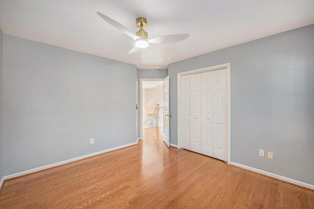 unfurnished bedroom featuring light hardwood / wood-style flooring, ceiling fan, and a closet