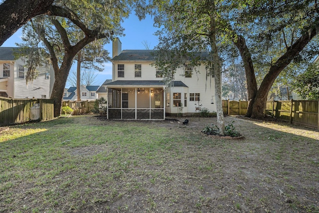 back of house with a sunroom and a lawn