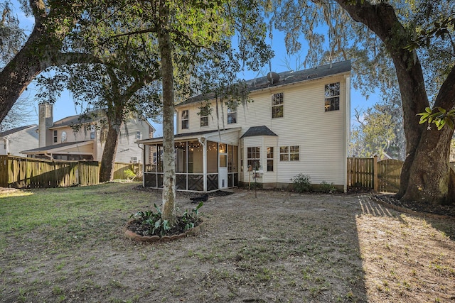 back of property featuring a lawn and a sunroom