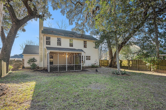 rear view of property with a sunroom and a lawn