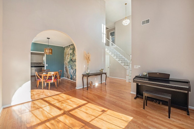 foyer featuring a notable chandelier, a towering ceiling, and hardwood / wood-style floors