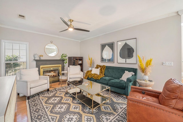 living room featuring hardwood / wood-style flooring, ornamental molding, and ceiling fan