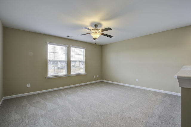 carpeted spare room featuring ceiling fan